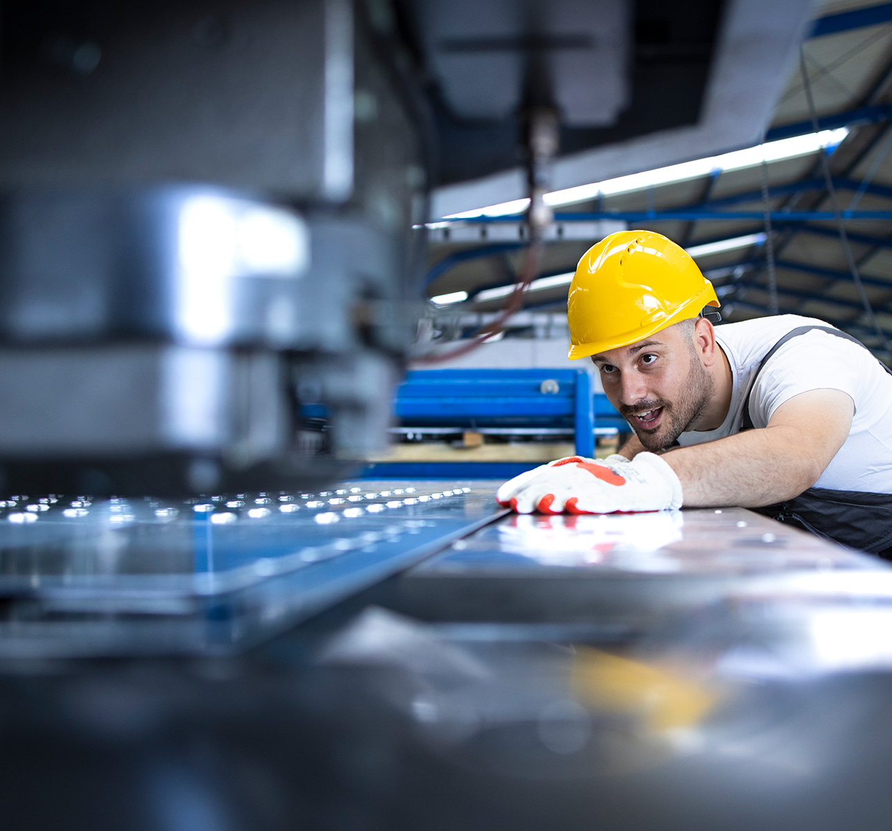 The builder in a construction vest and orange helmet standing against industrial background. Safety specialist, engineer, industry, architecture, manager, occupation, businessman, job concept